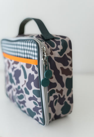 Patterned toiletry bag with a checkered flap on a white background