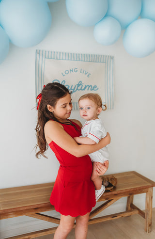 Girl wearing red ribbed scallop athletic set with matching top and skort