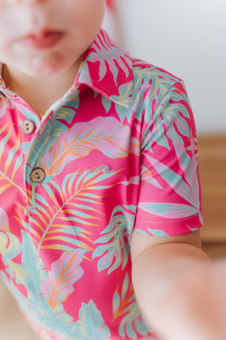 Child wearing a colorful tropical patterned shirt with a blurred background