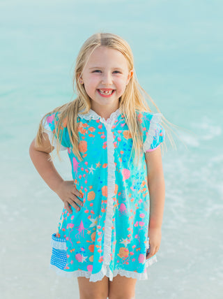 Young girl wearing a colorful swimsuit with a blue background