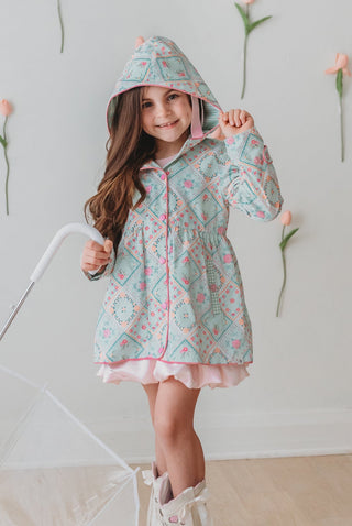 Child wearing a floral raincoat with a white background and flower decorations