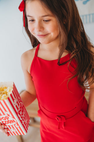 Girl wearing red ribbed scallop athletic set with matching top and skort