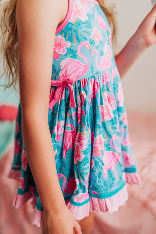 Child wearing a colorful dress with flamingo pattern