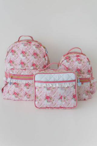 Set of pink floral backpack and lunchbox on a white background