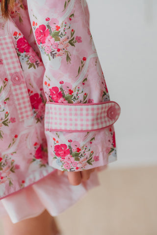 Close-up of a pink floral rain jacket with a white background