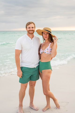 Man and woman standing on a beach with ocean in the background
