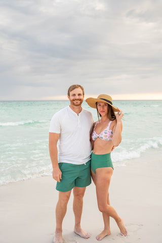 Man and woman standing on a beach with ocean in the background