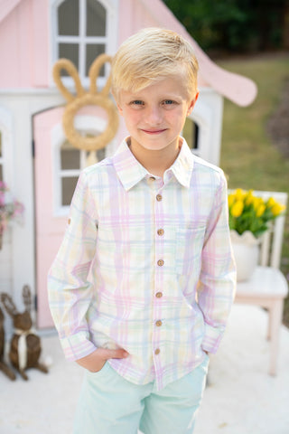 Young boy wearing a pastel plaid shirt with Easter themed decorations.