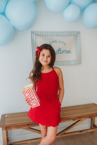  Girl wearing red ribbed scallop athletic set with matching top and skort