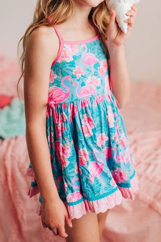 Young girl in a floral dress holding a light bulb in a bedroom.