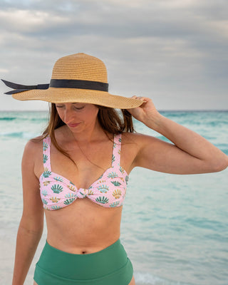 Woman in a bikini and sun hat on a beach