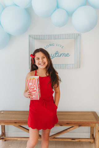  Girl wearing red ribbed scallop athletic set with matching top and skort