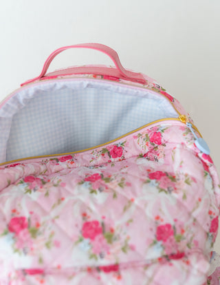 Floral-patterned bag with a pink handle on a white background